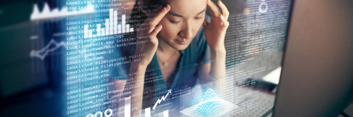 Shot of a young programmer looking stressed while using a computer at night in a modern office